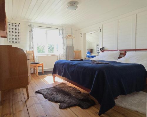 a bedroom with a bed with a blue blanket on it at The Sheep Inn B&B in Arvika