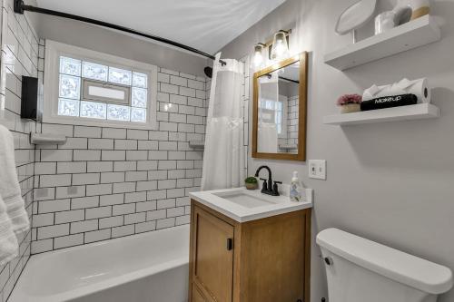 a bathroom with a sink and a toilet and a mirror at New 3BDRM Centrally Located Free Parking AC in Buffalo