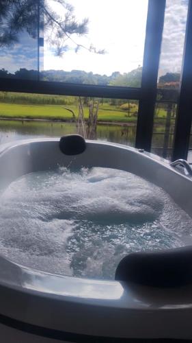 a bath tub filled with water in front of a window at Verde Vale in Nova Petrópolis