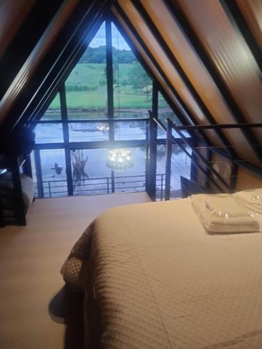 a bedroom with a bed and a view of the water at Verde Vale in Nova Petrópolis