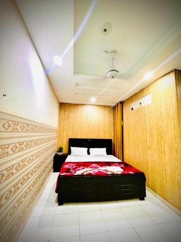 a bedroom with a bed with a red comforter at Palace inn Hotel in Dargai