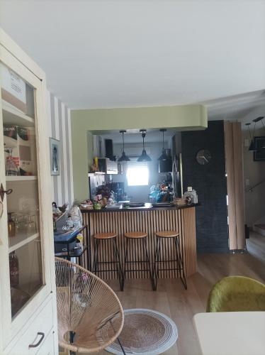 a kitchen with a bar and stools in a room at Eugénie86 in Poitiers