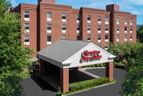 a rendering of a building with a sign in front of it at Hampton Inn & Suites Charlottesville at the University in Charlottesville