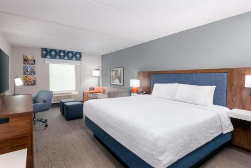 a hotel room with a large bed and a desk at Hampton Inn & Suites Charlottesville at the University in Charlottesville