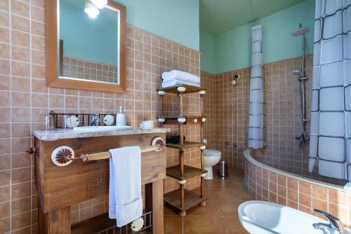 a bathroom with a sink and a tub and a mirror at Hotel Rural Sierra Tejeda in Alcaucín