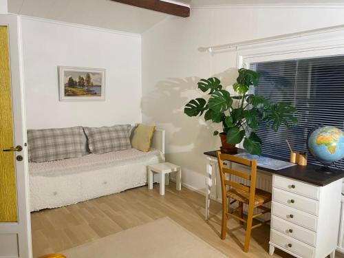 a living room with a couch and a desk at Huone lintukodossa in Helsinki