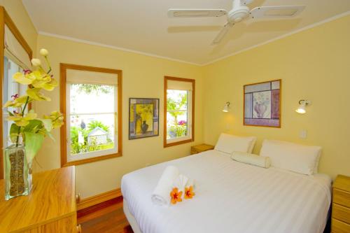 a bedroom with a white bed with flowers in a vase at Seaport Village in Russell