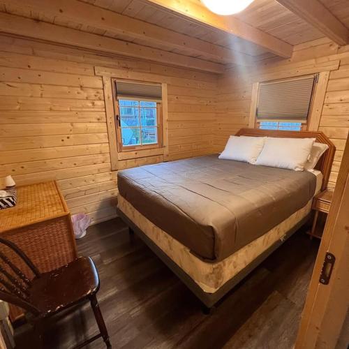 a bedroom with a bed in a log cabin at Terrawoods Pine Cottage in Parry Sound