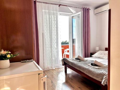a bedroom with a bed and a large window at room MLIN 2 in Jakišnica