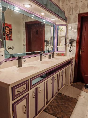 a bathroom with two sinks and a large mirror at Your Home In Riyadh Hostel in Riyadh