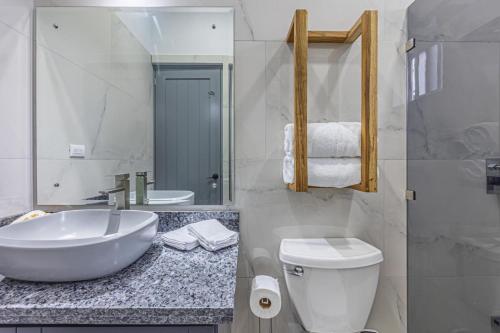 a white bathroom with a sink and a toilet at Casamar in Uvita