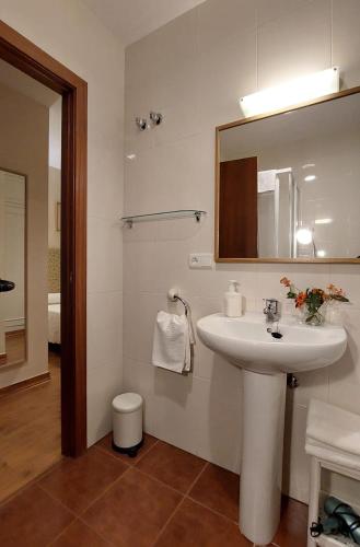 a bathroom with a sink and a mirror and a toilet at Casa Rural Maria in Molinaseca