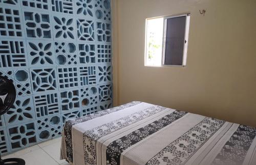 a room with a bed and a wall with a window at Chácara Santa Teresinha Crato in Crato