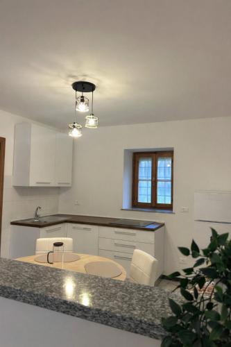 a kitchen with a table and some white cabinets at Il Nido sul Lago B&B in Viverone