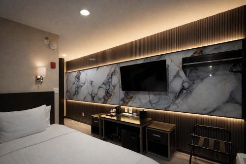 a hotel room with a bed and a flat screen tv at Grandview Hotel New York in Queens