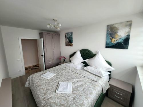 a bedroom with a large bed with white sheets at Luxury apartment Avanera in Suceava