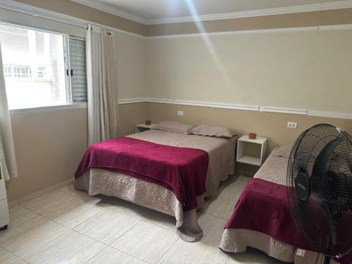 a bedroom with a bed and a fan at Casa Canto do Rio in Socorro