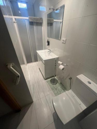 a white bathroom with a sink and a toilet at La Morada del Jucar in Cuenca