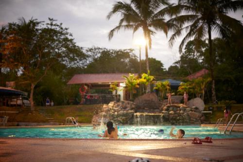 un grupo de personas en una piscina en un complejo en Hostería Ojo de Agua en Loreto