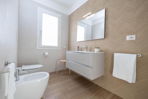 a bathroom with a white sink and a mirror at Corona Guest House in Sestu