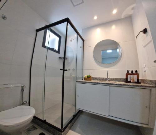 a bathroom with a shower and a toilet and a mirror at Vista Espetacular e Estúdio Novo in Niterói