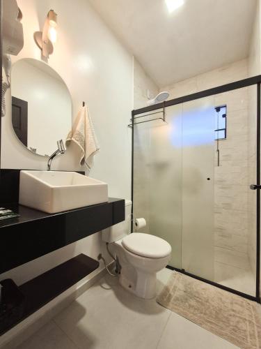 a bathroom with a toilet and a sink and a shower at Frieden Haus Hospedagem in Pomerode