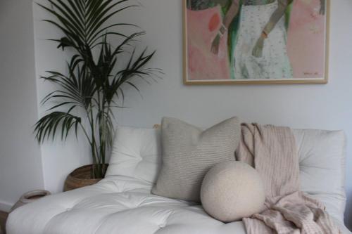 a white couch in a living room with a plant at Bohemian Beach Retreat in Donja Lastva