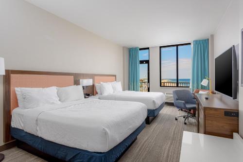 a hotel room with two beds and a desk and a television at Hampton Inn & Suites - Orange Beach in Orange Beach