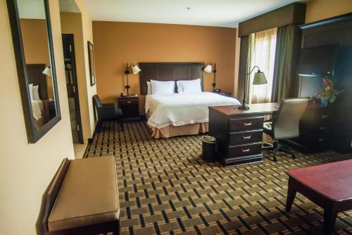 a hotel room with a bed and a desk at Hampton Inn & Suites Palestine in Palestine