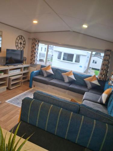 a living room with a couch and a television at Buckingham Breeze Haven Caravan Hire Marton Mere Blackpool in Marton