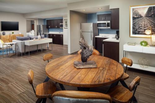 a kitchen and living room with a wooden table and chairs at Homewood Suites Savannah Historic District/Riverfront in Savannah