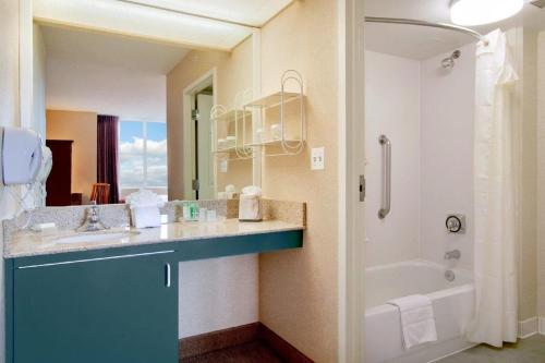 a bathroom with a sink and a tub and a shower at Homewood Suites by Hilton Falls Church in Merrifield