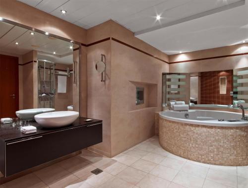 a large bathroom with a tub and a sink at Hilton Diagonal Mar Barcelona in Barcelona