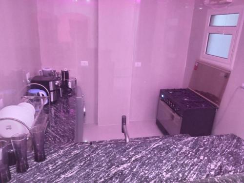 a kitchen with purple walls and a stove at Luxor lights palace in Luxor