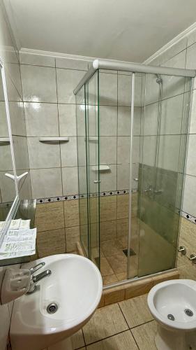 a bathroom with a sink and a glass shower at Azul Hotel Oberá in Oberá