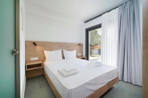 a bedroom with a bed and a large window at Pine Suites in Potos