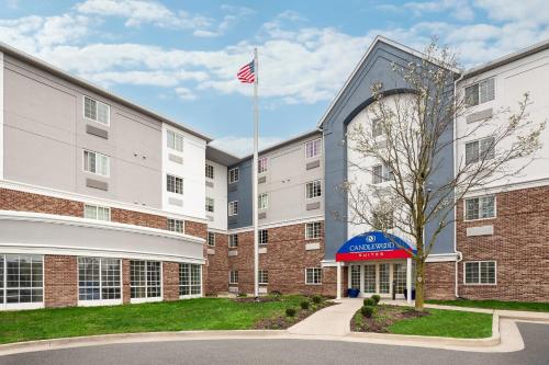 an exterior view of a building with an american flag at Candlewood Suites Indianapolis Northeast by IHG in Indianapolis