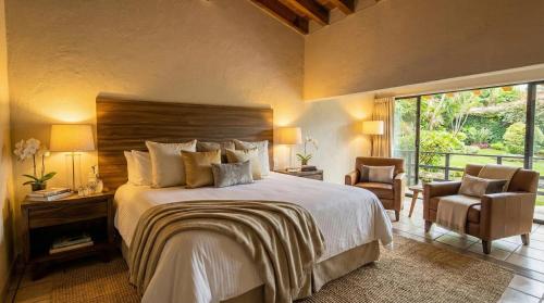 a bedroom with a large bed and a large window at Orgánico Hotel Boutique VALLE DE BRAVO in Valle de Bravo