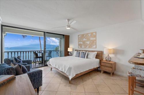 a bedroom with a bed and a view of the ocean at Lahaina203 in Lahaina