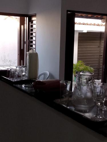 a table with glasses on a counter with a mirror at Casa praia de Barra nova 6 km de Maceió in Marechal Deodoro