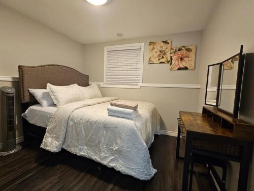 a bedroom with a bed and a desk and a mirror at Modern Comfort Haven Near Reversing Falls Bridge Saint John NB in Saint John