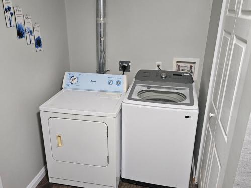 a stove and a washer and dryer in a room at Modern Comfort Haven Near Reversing Falls Bridge Saint John NB in Saint John