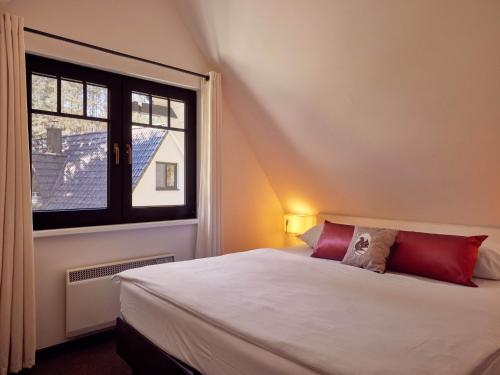 a bedroom with a white bed and a window at Ferienhäuser im Naturresort Drewitz in Drewitz