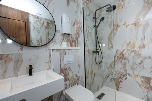a bathroom with a shower and a sink and a mirror at Elite Home in Maarif