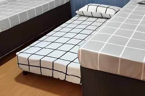 two beds sitting next to each other in a room at Paz e natureza! Descanso e tranquilidade! in Rio das Ostras