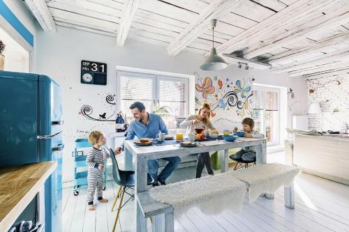 a family sitting at a table in a kitchen at Apartmán Malý princ in Dolní Lomná