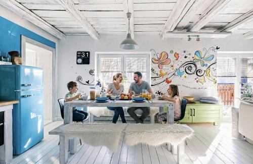 a family sitting at a table in a kitchen at Apartmán Malý princ in Dolní Lomná