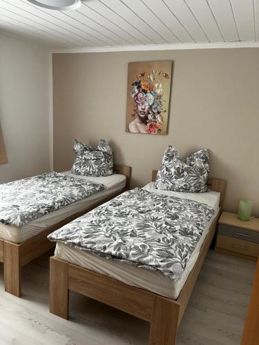 two twin beds in a room with a painting on the wall at Hinterhaus-Idyll Markranstädt in Markranstädt
