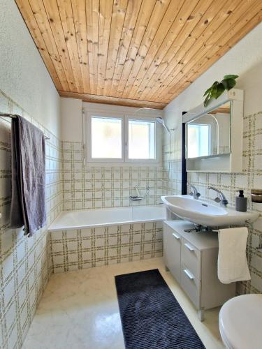 a bathroom with a sink and a tub and a toilet at Lakeview-Apartment - Komplette Wohnung mit Seeblick an ruhiger Lage in Weesen
