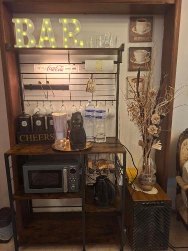 a table with a microwave and a sign that says bar at Malta Airport B&B bedroom with private shower